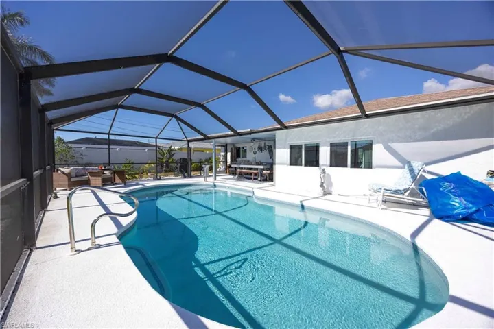 Swimming pool featuring a sunroom, a patio, glass enclosure, and an outdoor living space