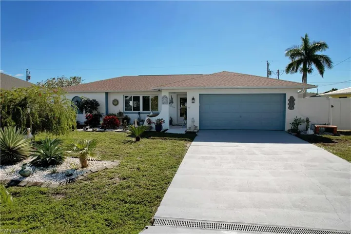 Single story home with concrete driveway, stucco siding, an attached garage, and a front lawn