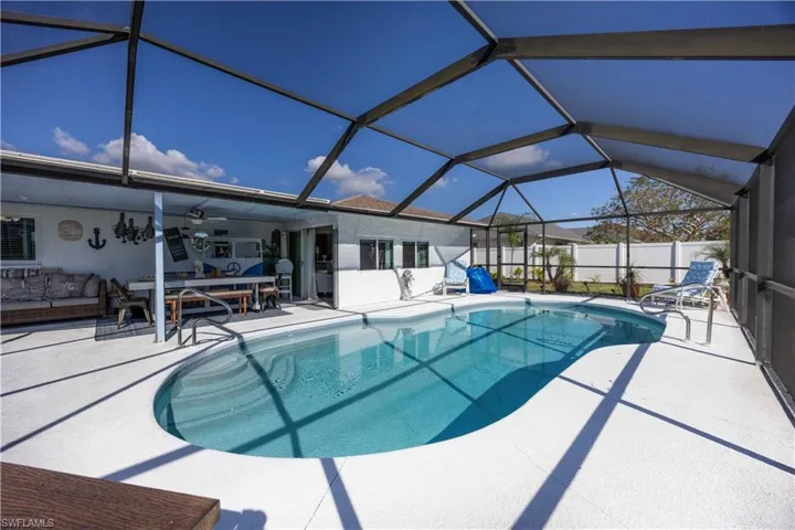 View of swimming pool featuring a lanai, a sunroom, an outdoor living space, and a patio