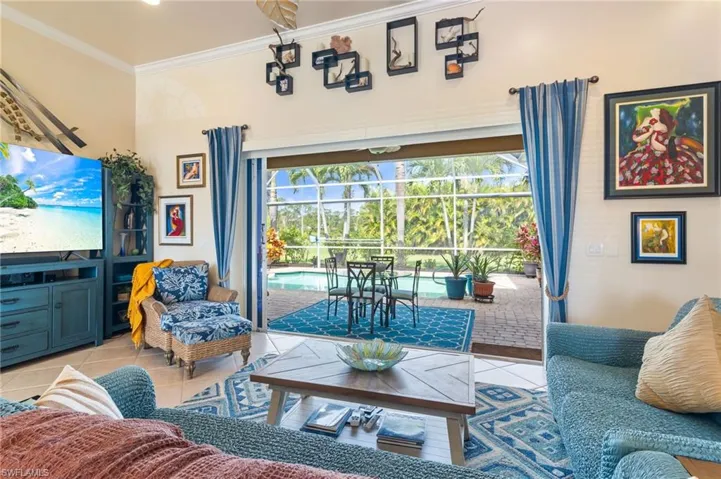 Living room with ornamental molding and light tile floors
