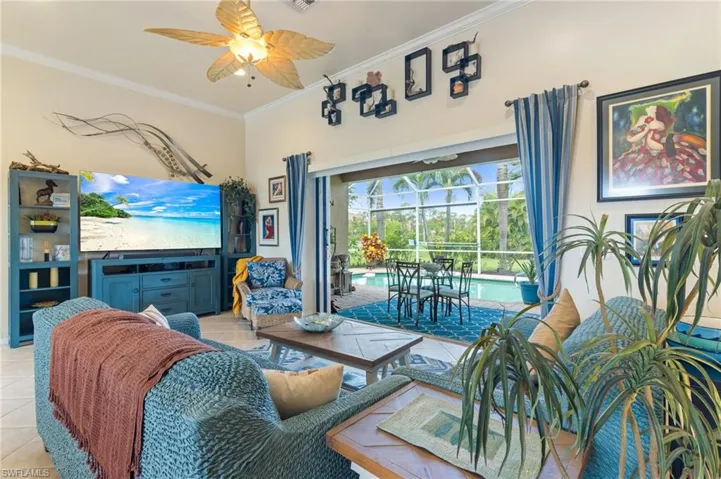 Tiled living room with ornamental molding and ceiling fan