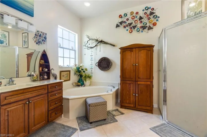 Bathroom with tile flooring, vanity, and plus walk in shower