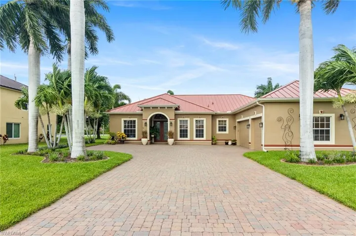 Mediterranean / spanish-style home featuring a garage and a front lawn