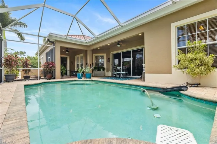 View of swimming pool with a patio, a lanai, and ceiling fan