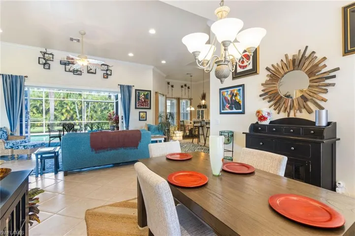 Dining room with a chandelier, light tile flooring, and ornamental molding