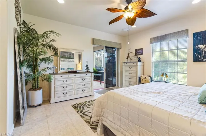 Tiled bedroom featuring ceiling fan and access to outside