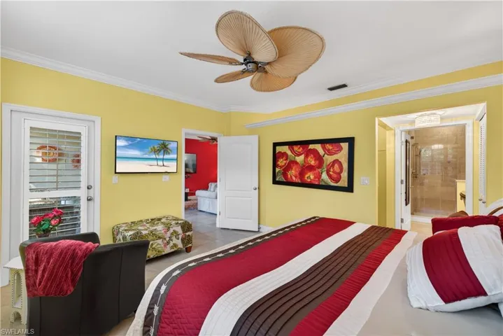 This room features a ceiling fan, crown molding, and yellow walls