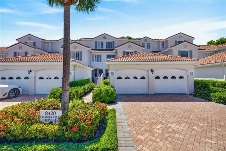 The property features a stucco exterior with a tile roof, an attached garage, and a paver driveway