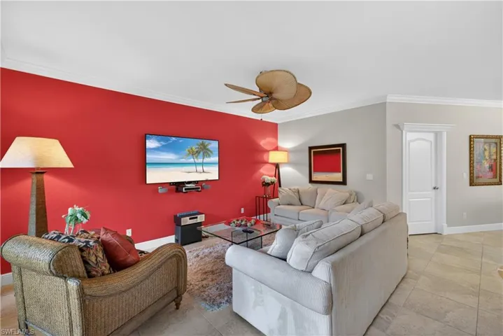 The living area features a bright accent wall, a ceiling fan, and tiled flooring