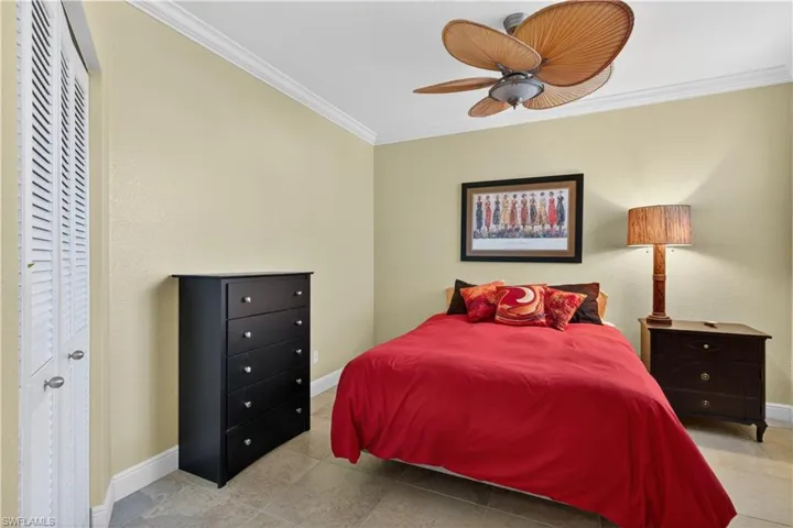 This room features crown molding, light-colored walls, and tiled flooring