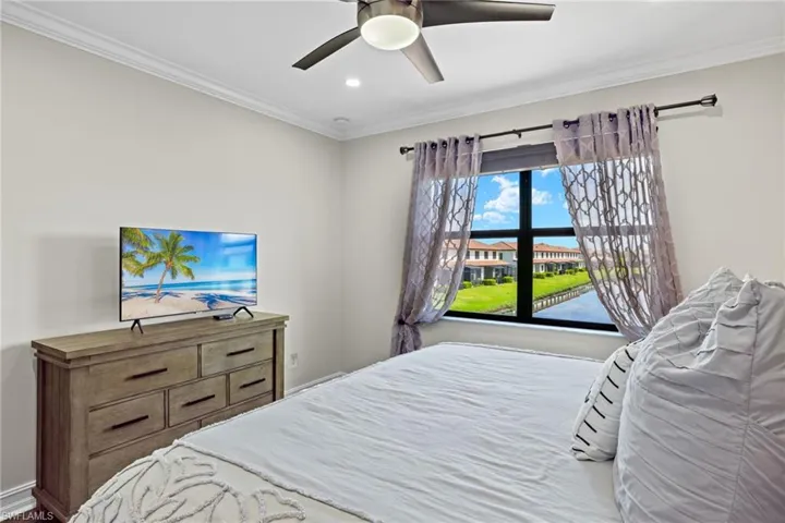 Bedroom with ceiling fan and crown molding