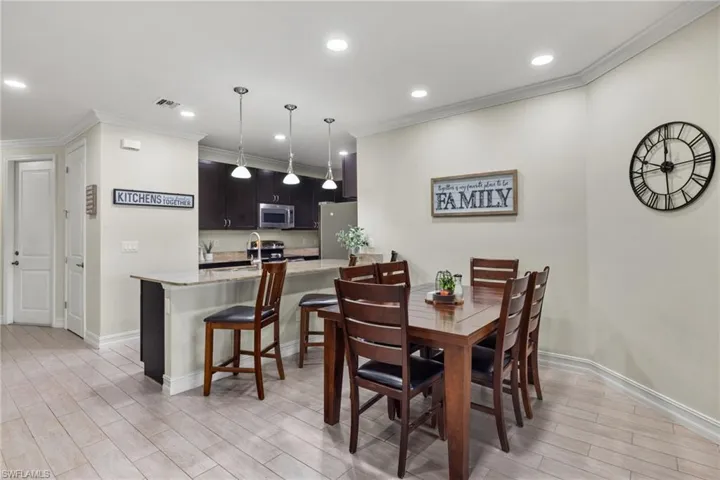Dining room with light hardwood / wood-style floors and crown molding