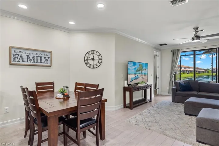 Dining room with ceiling fan, crown molding, and light hardwood / wood-style floors