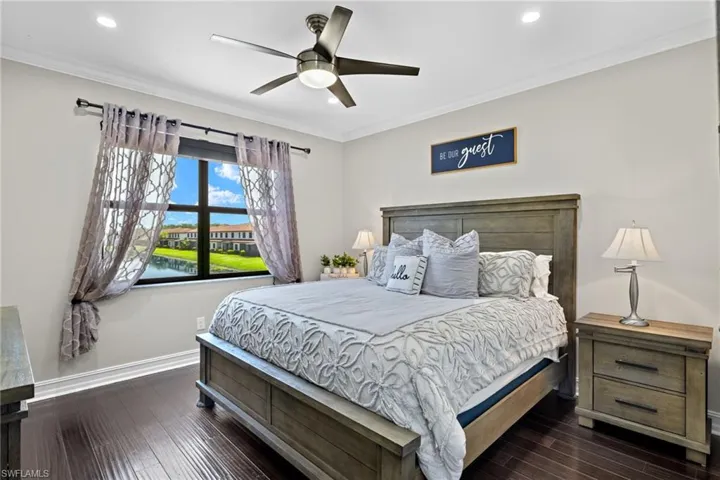 Bedroom with ceiling fan, crown molding, and dark hardwood / wood-style flooring