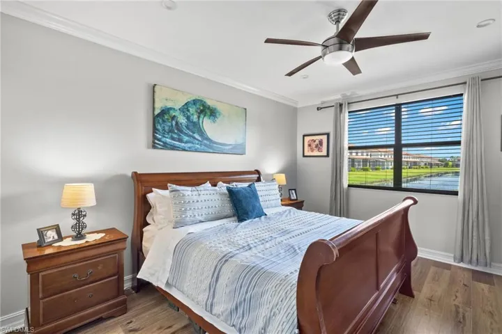 Bedroom featuring wood-type flooring, ceiling fan, and crown molding