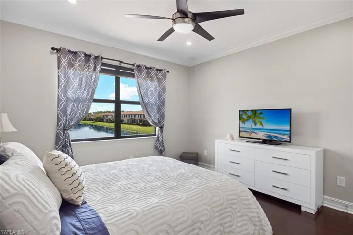 Bedroom featuring ornamental molding, dark hardwood / wood-style flooring, and ceiling fan