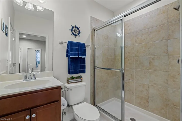 Bathroom with vanity, toilet, and an enclosed shower