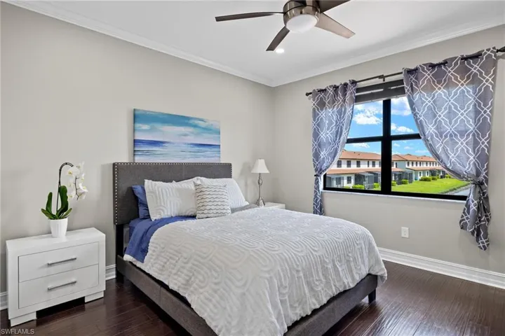 Bedroom with crown molding, dark wood-type flooring, and ceiling fan