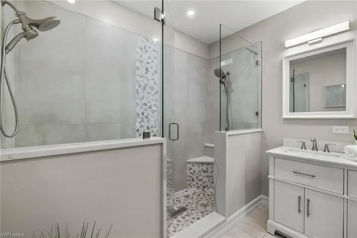 Bathroom with wood-type flooring, walk in shower, and vanity