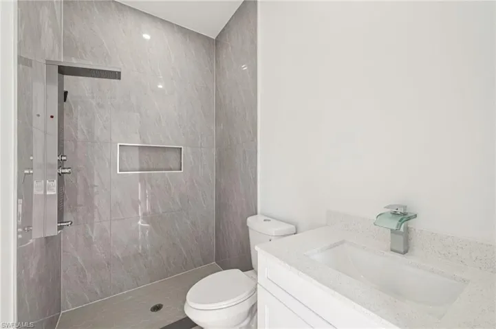 Full bath featuring vanity and a tile shower