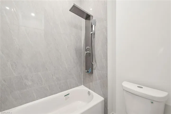 Full bathroom with washtub / shower combination and toilet