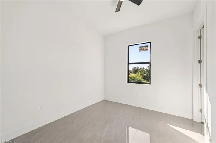 Unfurnished room with baseboards and a ceiling fan