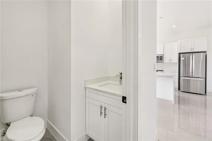 Half bath with vanity, light tile patterned floors, and recessed lighting