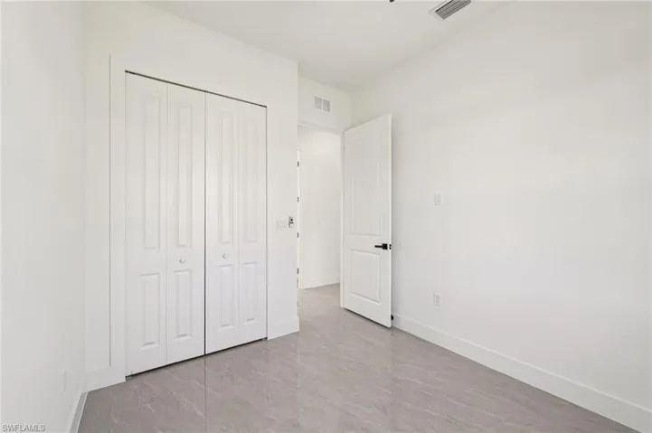 Unfurnished bedroom featuring a closet and baseboards