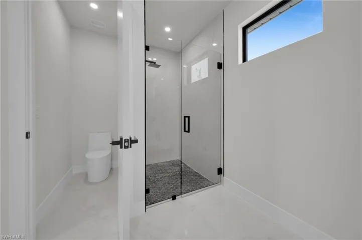 Full bathroom featuring marble finish flooring, a marble finish shower, baseboards, toilet, and recessed lighting