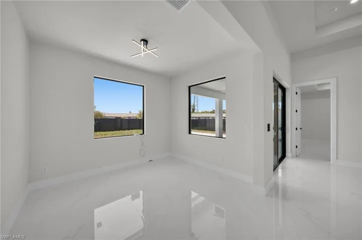 Unfurnished room with marble tiled flooring and baseboards