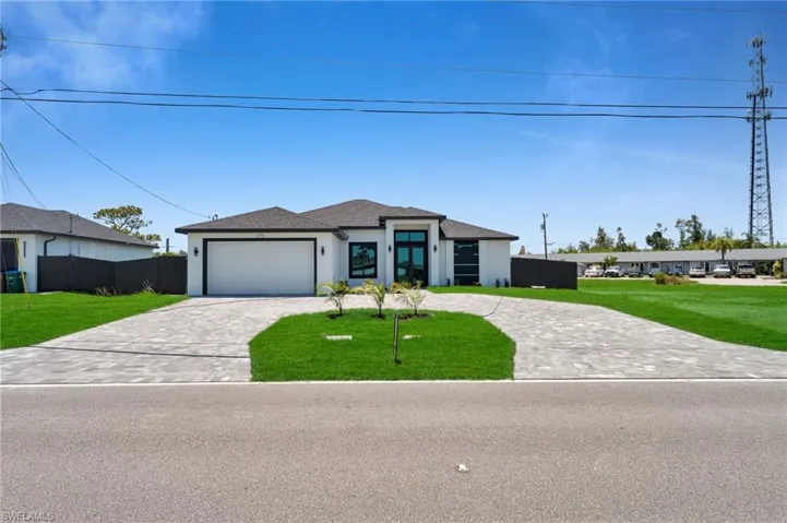 View of front of home featuring decorative driveway, an attached garage, and stucco siding