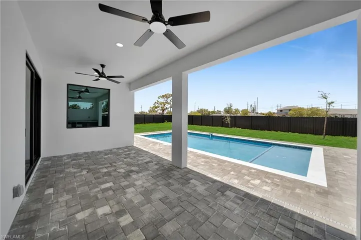 View of pool with a ceiling fan and a patio