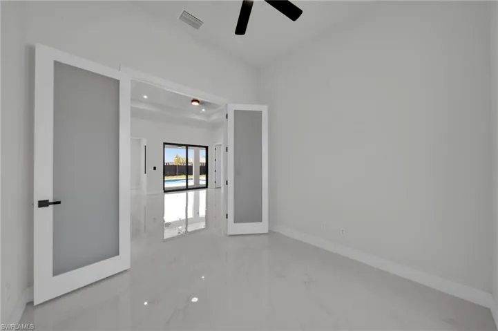 Empty room featuring marble tiled flooring, a ceiling fan, baseboards, and recessed lighting