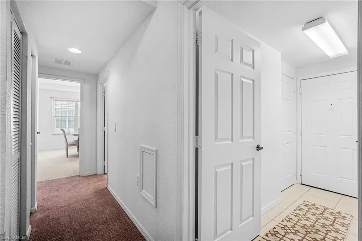 Hall featuring a textured ceiling, light tile patterned floors, and recessed lighting