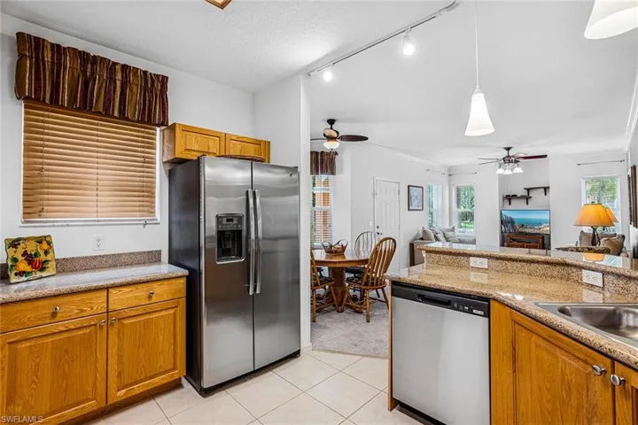 Kitchen featuring stainless steel appliances, ceiling fan, and brown cabinets
