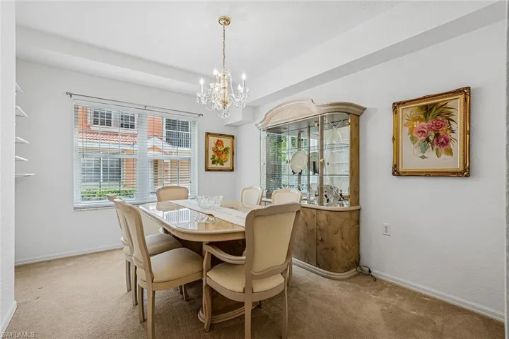 Dining room featuring light carpet and a chandelier