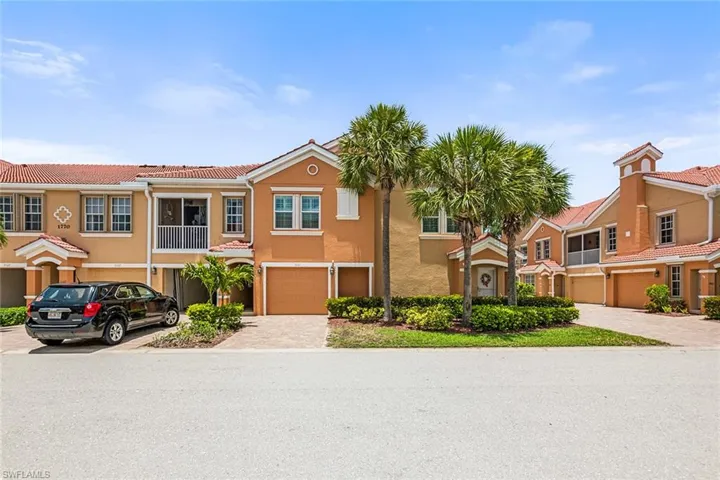 Multi unit property featuring stucco siding, a tiled roof, driveway, an attached garage, and a residential view