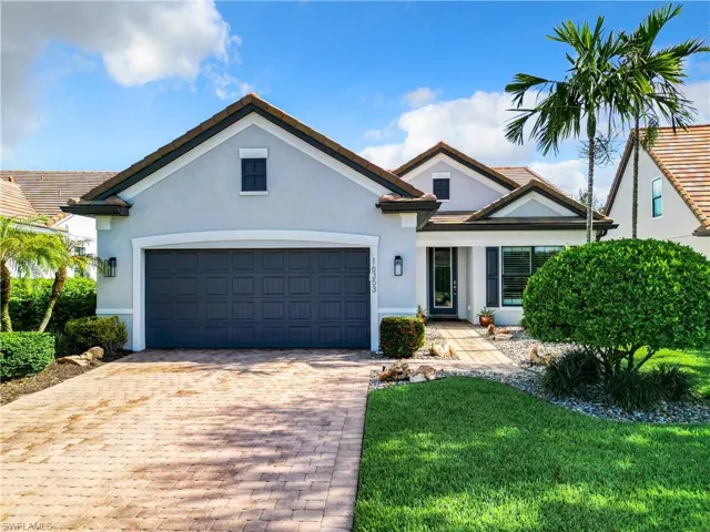 View of front of property featuring a front yard and a garage