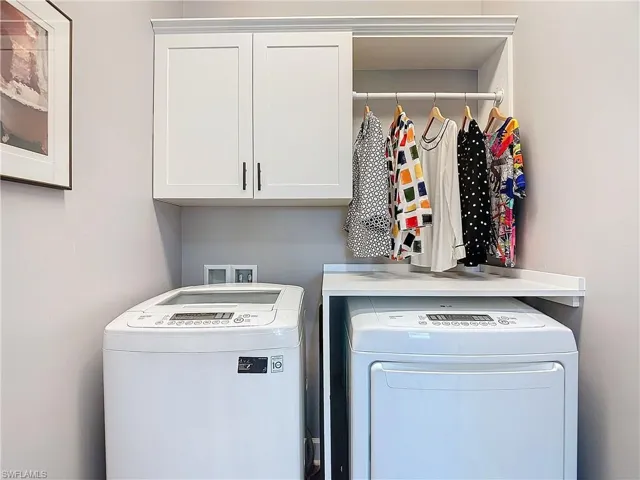 Laundry area with cabinets and washing machine and clothes dryer