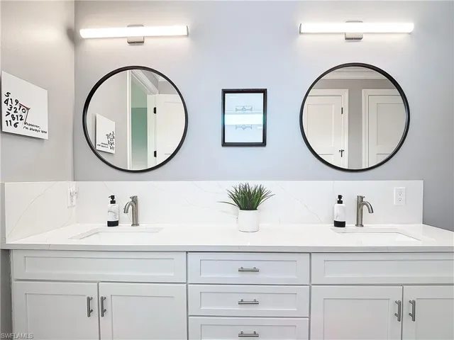 Bathroom with vanity and tasteful backsplash