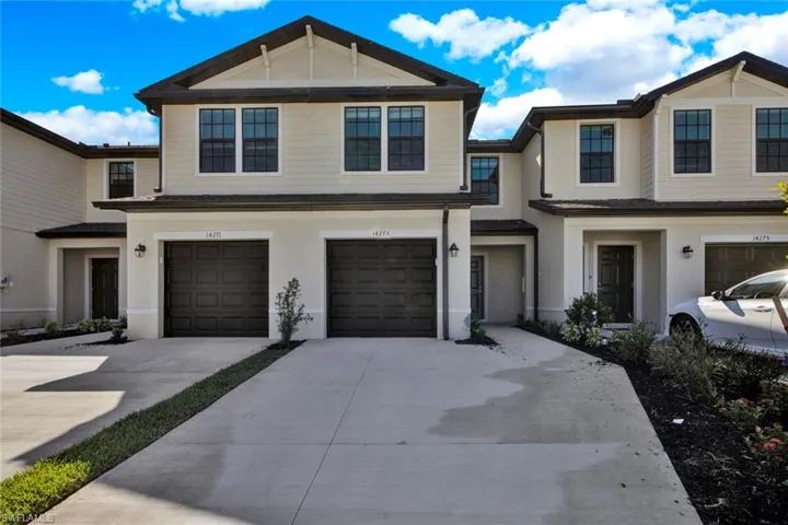 Multi unit property featuring driveway, a garage, and stucco siding