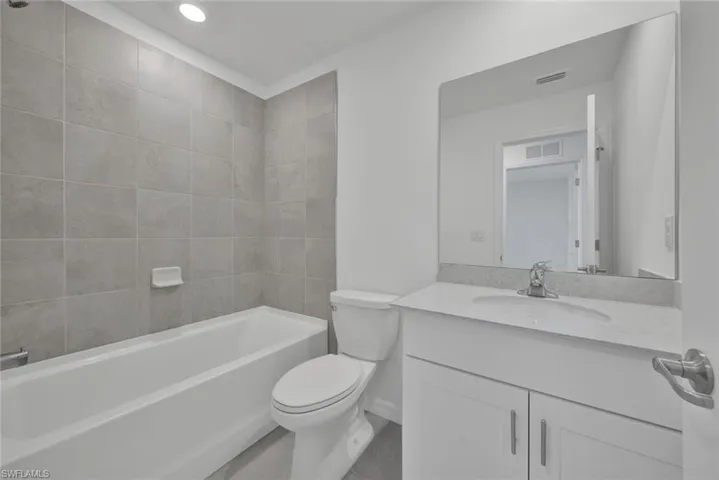 Bathroom with vanity, toilet,  shower combination, and recessed lighting