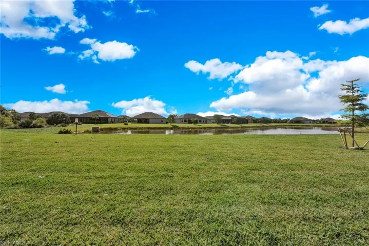 View of green lawn with a water view and a residential view