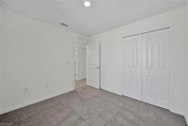 Unfurnished bedroom with carpet floors, baseboards, and a closet