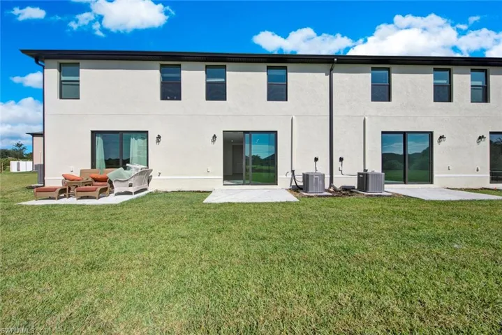 Rear view of property featuring a patio area, central air condition unit, a yard, an outdoor hangout area, and stucco siding