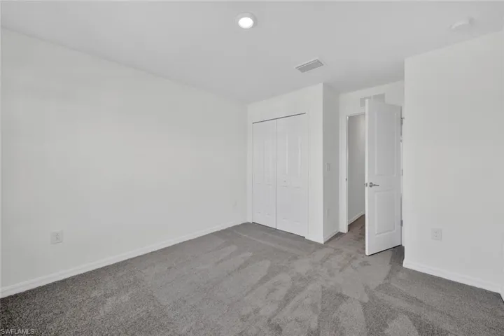 Unfurnished bedroom with carpet flooring, a closet, and baseboards