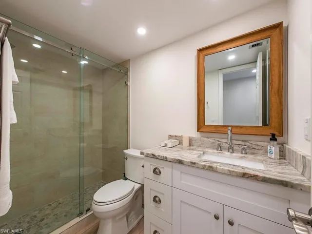 Bathroom with vanity, a stall shower, and recessed lighting