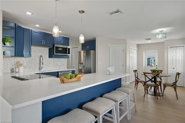 Kitchen with sink, stainless steel appliances, kitchen peninsula, light hardwood / wood-style floors, and a breakfast bar