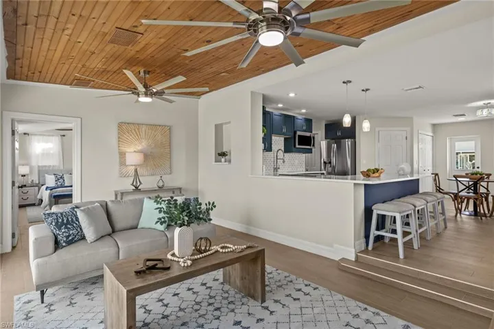 Living room featuring wooden ceiling, sink, a healthy amount of sunlight, and light wood-type flooring
