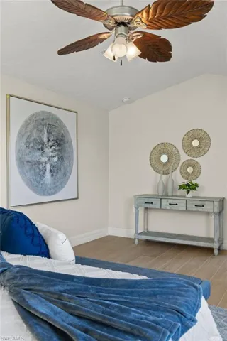 Bedroom featuring hardwood / wood-style flooring, vaulted ceiling, and ceiling fan